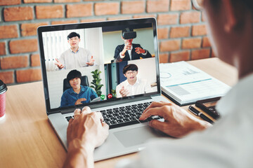 Asian man working from home use Smart working and video conference online meeting with Asian team...