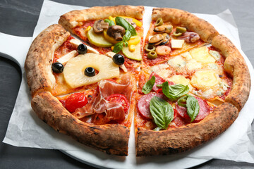 Slices of different pizzas on grey table, closeup
