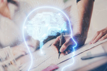 Double exposure of woman's writing hand on background with brain hud. Concept of learning.