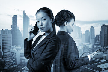 Two young attractive business woman in suits working on project together to gain new career opportunities. Concept of multinational corporate team in Bangkok. Double exposure.