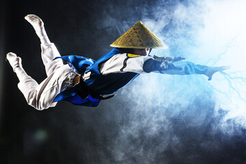 Cosplay Shaolin monk in a straw hat flies through the air releases lightning from his hands on a...