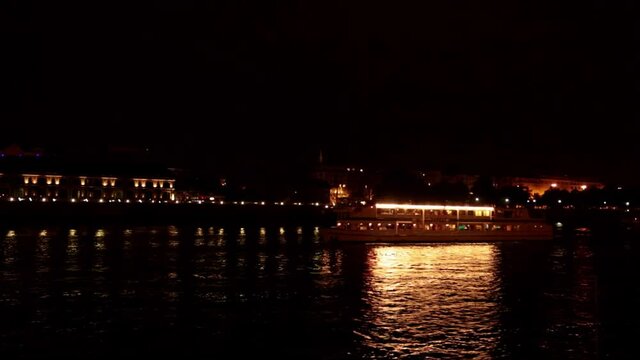 A boat passes under Bridge aser show on the Danube River