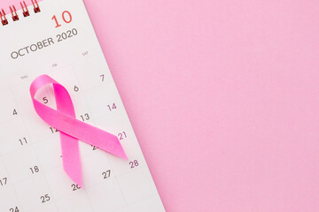 Breast Cancer concept : Top view pink ribbon and calendar symbol of breast cancer campaign on pink