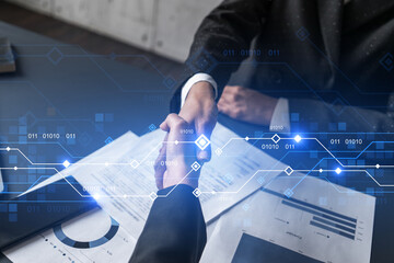 Double exposure of two businesspeople handshake and binary technology hologram drawing background....