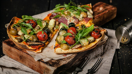 Food banner. Delicious pizza with vegetables, mozzarella, olives and herbs on a cutting board on a dark background. Mediterranean Kitchen