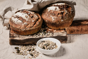 Homemade rye sourdough bread with sunflower seeds, nuts and caraway seeds. Homemade cakes on a gray background.
