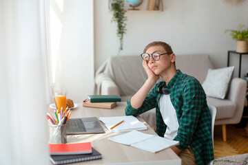 Tired school boy sleeping while doing homework