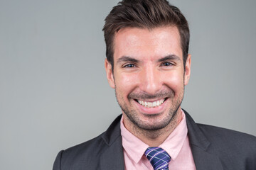 Portrait of happy young handsome Hispanic businessman in suit