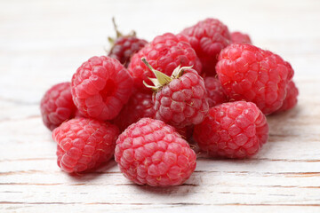 Delicious fresh ripe raspberries on white wooden table, closeup