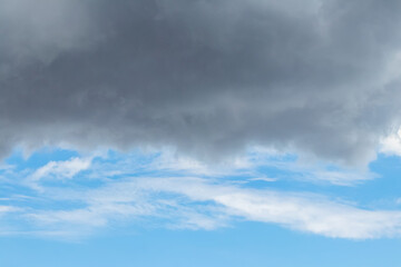 Dark rain cloud above the blue sky