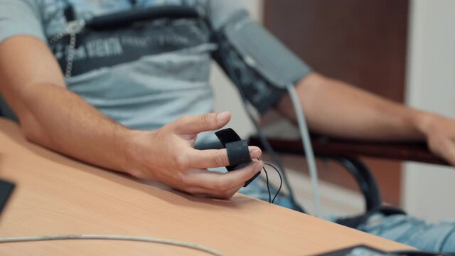 Man's hands connected to the lie detector circuit.