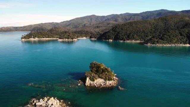 Pinnacle Island aerial orbit shot reveal of a beautiful landscape, Abel Tasman, New Zealand. Coastal line in paradise, formed by nature. Nice sunny day.