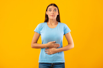 Young female model touching her stomach at studio