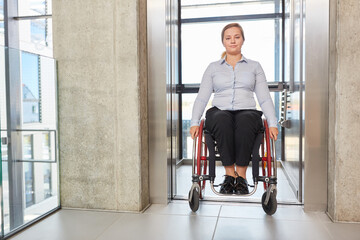 Fototapeta na wymiar Geschäftsfrau als Rollstuhlfahrer im Fahrstuhl