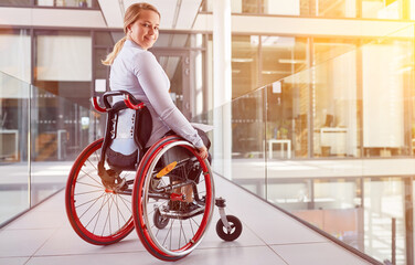 Geschäftsfrau im Rollstuhl im Büro als Inklusion Konzept