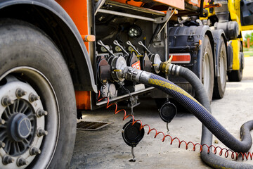 A gasoline tanker pours gasoline into an underground tank.