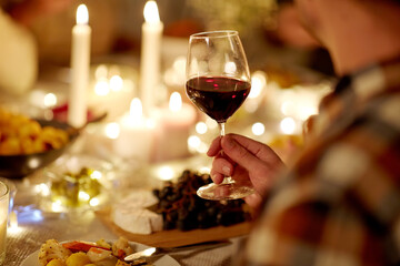 holidays, celebration and people concept - friends having christmas dinner party and drinking non-alcoholic red wine at home