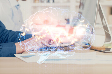 Businessman with computer background with brain theme hologram. Concept of brainstorm. Multi...