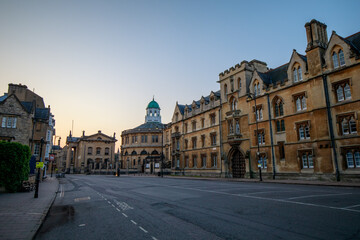Fototapeta na wymiar The Clarendon Building, The Sheldonian Theatre and Exeter College lining Broad Street in Oxford with no people or vehicles. Early in the morning. Oxford, England, UK.