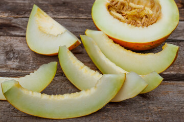 Sliced fresh sweet melon on a rustic wooden table