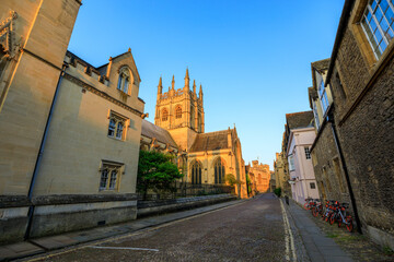Merton College Chapel, down a side street, in Oxford at sunrise with no people around, early in the morning on a clear day with blue sky. Oxford, England, UK.