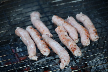 Sausages cooking on a small, old-fashioned barbecue