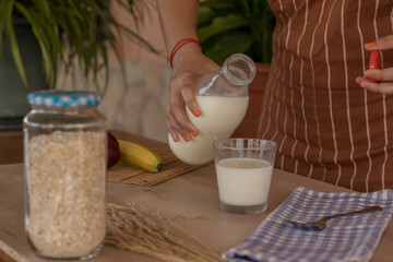 Mujer preparando un vaso de leche para desayunar 