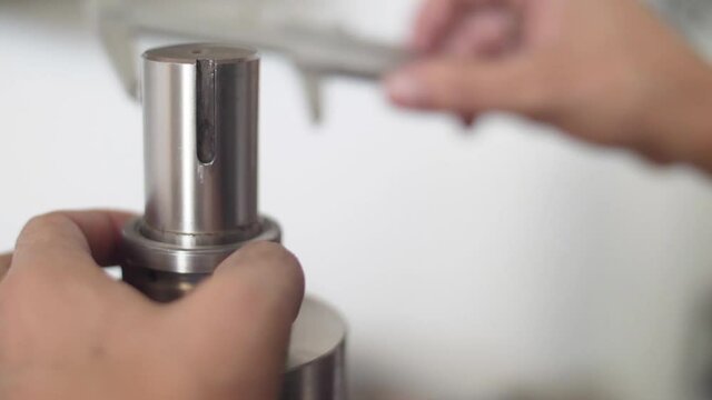 hands working with vernier caliper stainless steel measuring slow motion