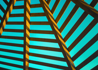 Abstract pattern of wooden structure with boards against a blue sky