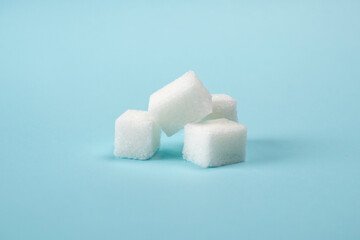 Sugar cubes isolated on a blue background. Health concept. World Diabetes Day concept.