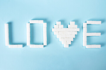 Heart and text love made from sugar cubes. Sugar harm. World diabetes day concept. Place for text.
