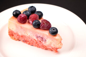 Cheesecake with berries on a white plate. Concept food photography. Sweets and berries. Copy space.