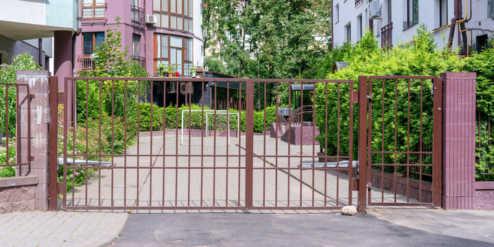 large red iron guard gate in entrance to private house on urban street