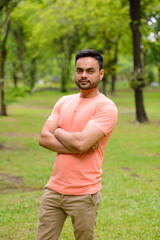 Young handsome bearded Indian man at the park