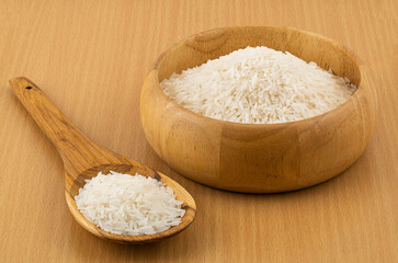 Fototapeta na wymiar Jasmine rice filled in a wooden bowl and in a wooden spoon.