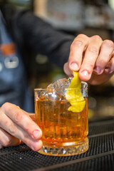 Barman mentre prepara un cocktail poggiato sul bancone di un bar
