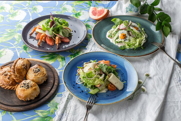 three different salads and bread bun for the menu on the table