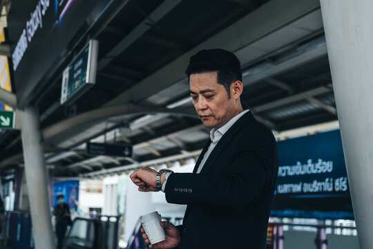 Business man looking at his watch while waiting at train station stock photo