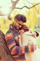 Couple hugging in the park on a sunny autumn day