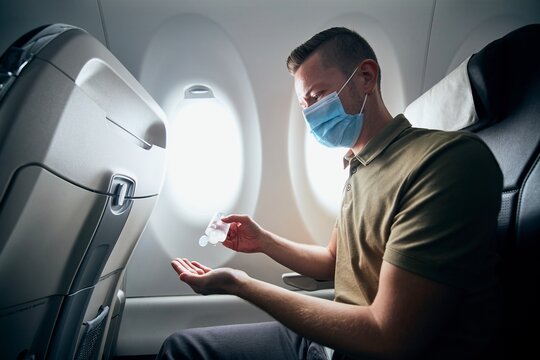 Man wearing face mask inside airplane
