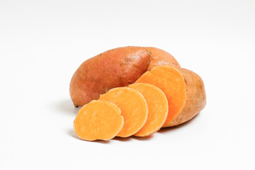 Farm raised organic sweet potato tubers laid in composition on textured background. The edible tuberous root vegetable on table counter. Clean eating concept. Background, close up, flat lay, top view.