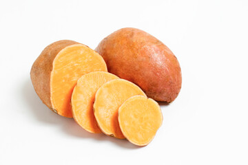 Farm raised organic sweet potato tubers laid in composition on textured background. The edible tuberous root vegetable on table counter. Clean eating concept. Background, close up, flat lay, top view.