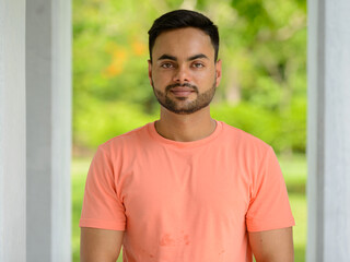 Young handsome bearded Indian man at the park