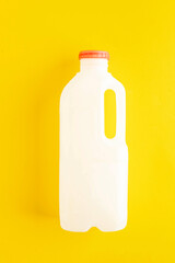 Unmarked biodegradable plastic milk bottle on a yellow background. Concept of dairy products. Zero...