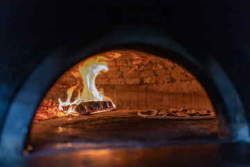 Pizza in cottura in un forno a legna 
