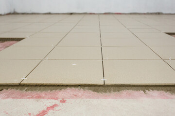 Fototapeta premium Fragment of the floor, in the process of laying ceramic tiles.