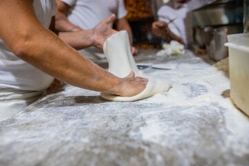 Pizzaiolo mentre stende una pizza