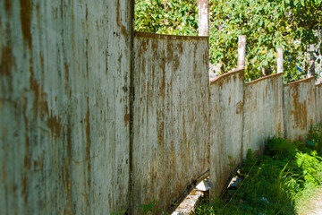 Old village house fence, road and plants