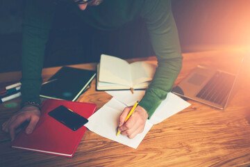 Obraz premium Cropped image of successful entrepreneur planning working process and thinking about good ideas for startup project.Creative male freelancer recording information while working remotely indoors
