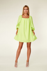 Pretty woman beautiful face bright makeup long blond hair fashion model wear trend clothes for date party summer walk travel cruise collection organic silk cotton dress accessory jewelry white studio.